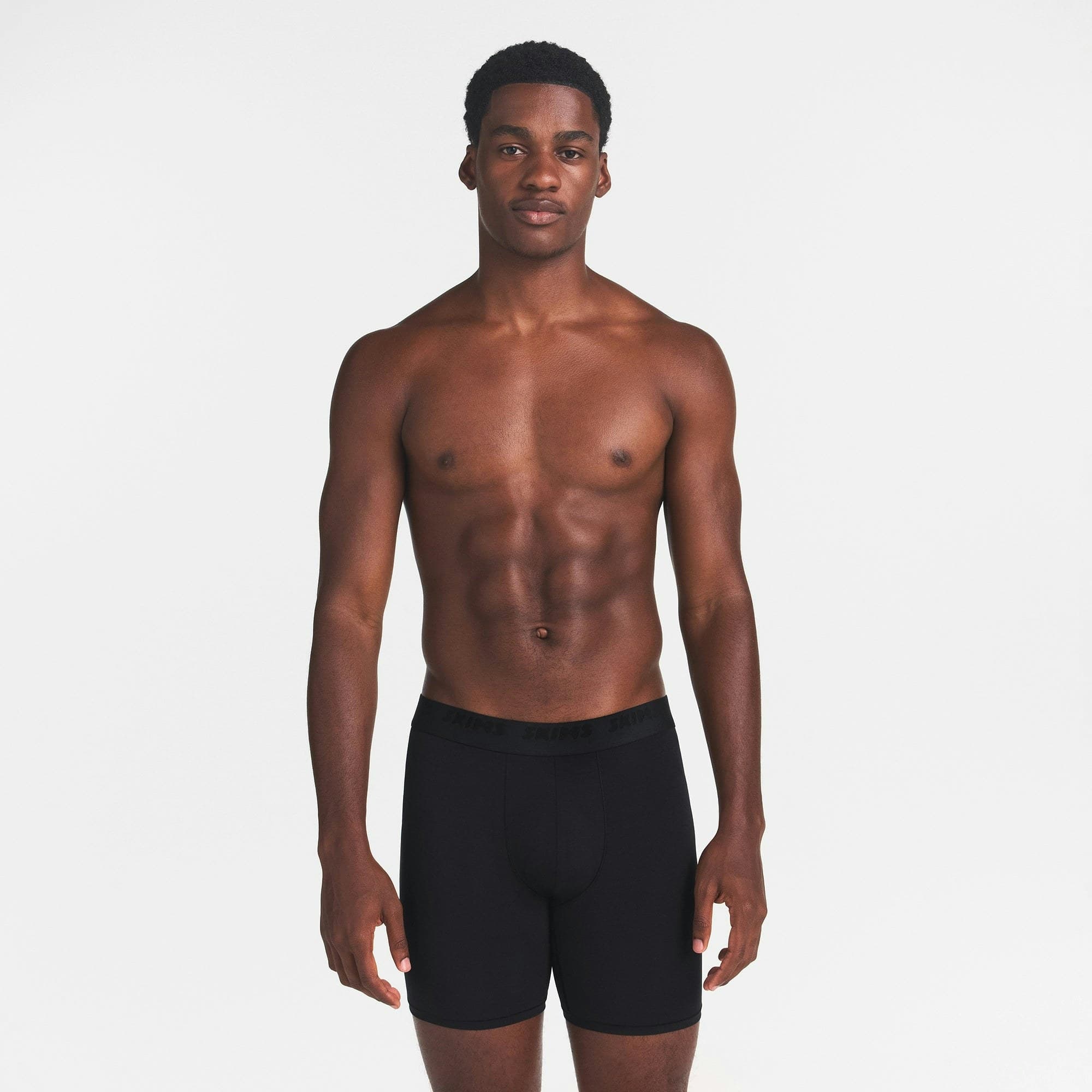 Model wearing black SKIMS Stretch 5-inch boxer briefs